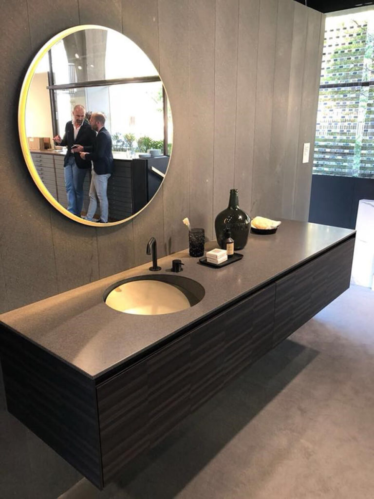 Le nuove finiture del corian, un legno scuro e il bronzo caratterizzano una composizione elegante (Corian Graylite + Bronze + Wood Tarsie Black ) negli allestimenti presentati nel Rogari-Rexa Design 